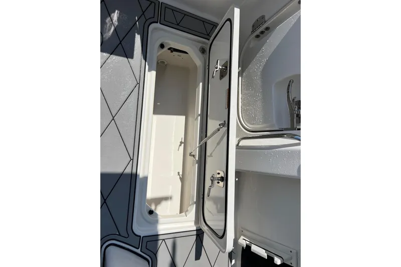 Yacht Photos Pics 2024 Pursuit S 328 Sport boat interior storage compartment with open door.