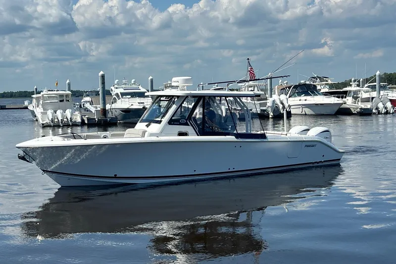  Yacht Photos Pics 2024 Pursuit S 328 Sport boat docked in a marina under a cloudy sky.