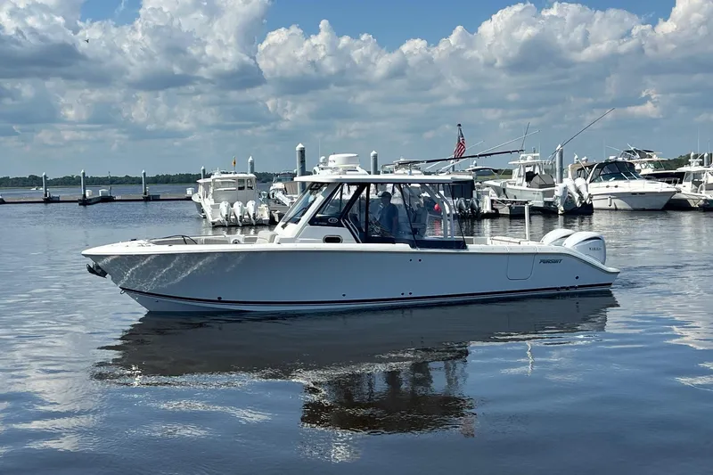  Yacht Photos Pics 2024 Pursuit S 328 Sport boat on calm water with cloudy sky background.
