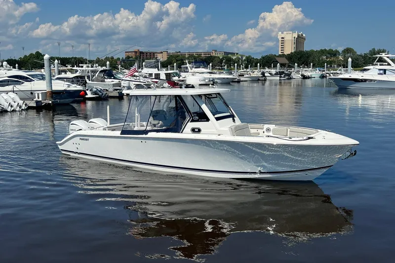  Yacht Photos Pics 2024 Pursuit S 328 Sport boat docked in a marina under a blue sky.