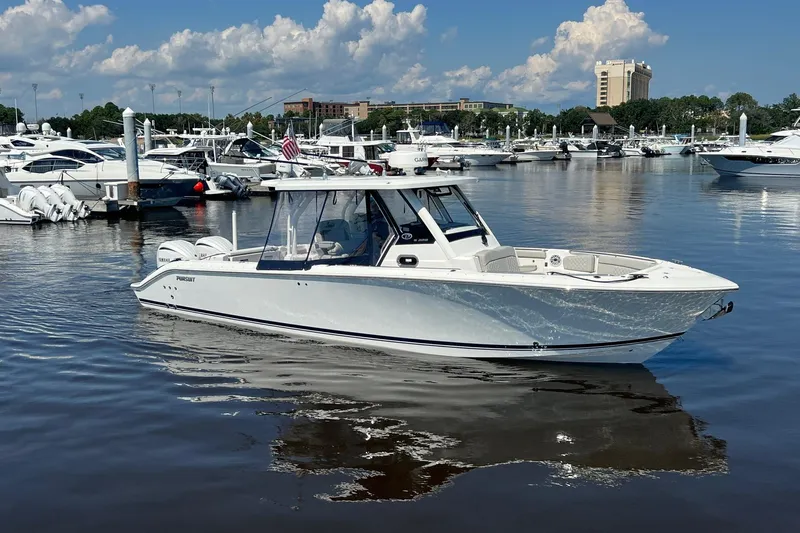 Yacht Photos Pics 2024 Pursuit S 328 Sport boat docked in a marina under a clear blue sky.