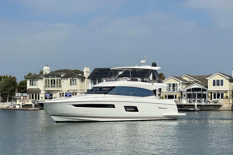 " La Bella Vita" Yacht Photos Pics 2017 Prestige 560 Flybridge yacht cruising near waterfront homes.