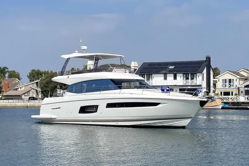 " La Bella Vita" Yacht Photos Pics 2017 Prestige 560 Flybridge yacht on calm water near waterfront homes.