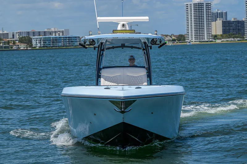  Yacht Photos Pics 2022 Fountain 34 CC boat cruising on water with city skyline in background.