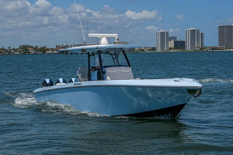  Yacht Photos Pics 2022 Fountain 34 CC boat cruising on water with city skyline in background.