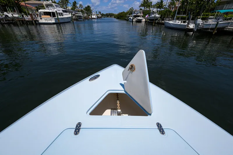  Yacht Photos Pics Bow view of 2022 Fountain 34 CC boat in a serene marina setting.