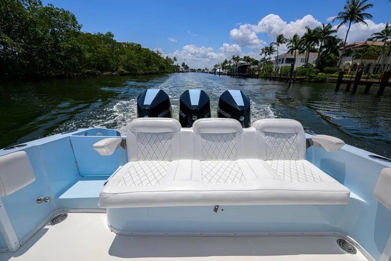  Yacht Photos Pics 2022 Fountain 34 CC boat with triple engines cruising on a scenic waterway.
