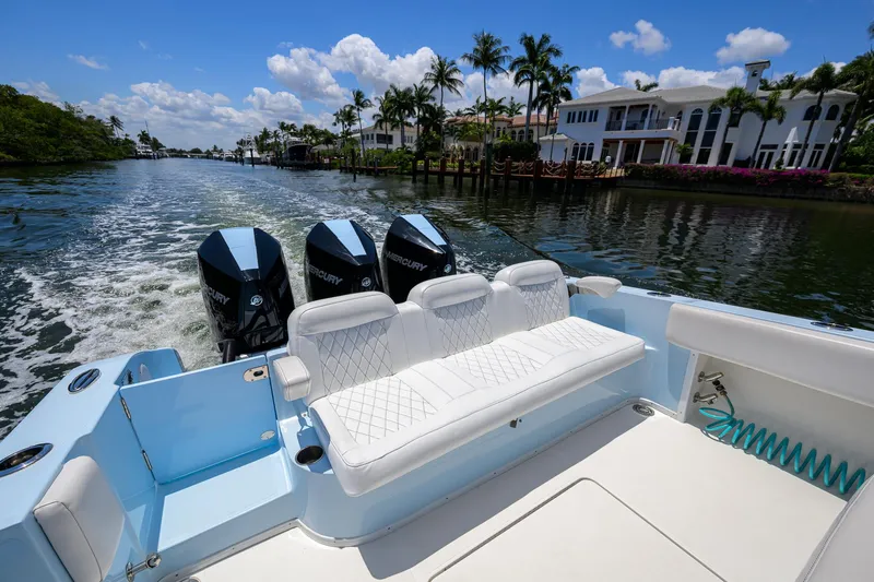  Yacht Photos Pics 2022 Fountain 34 CC boat with triple engines cruising on a scenic waterway.