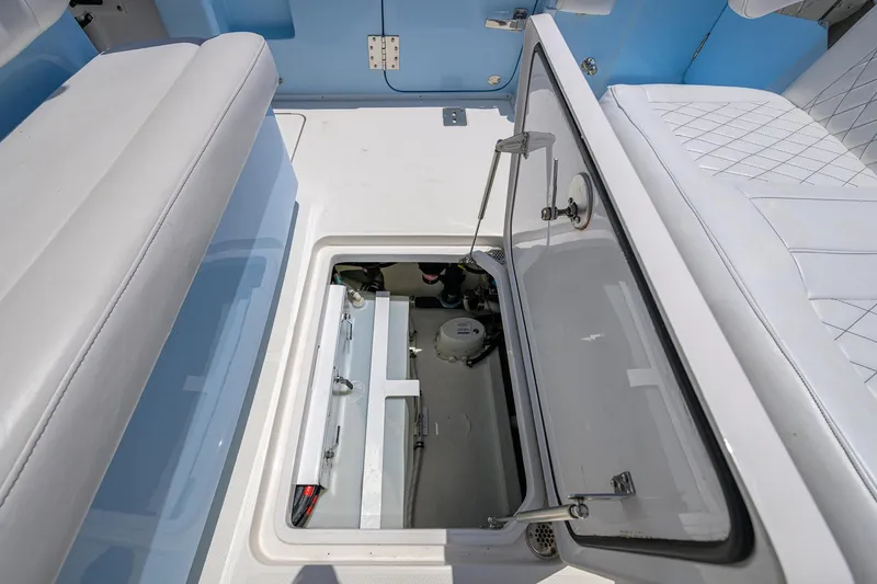  Yacht Photos Pics 2022 Fountain 34 CC boat interior with open storage compartment and cushioned seating.