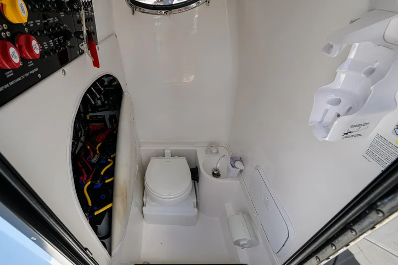  Yacht Photos Pics 2022 Fountain 34 CC boat interior with compact marine toilet and control panel.