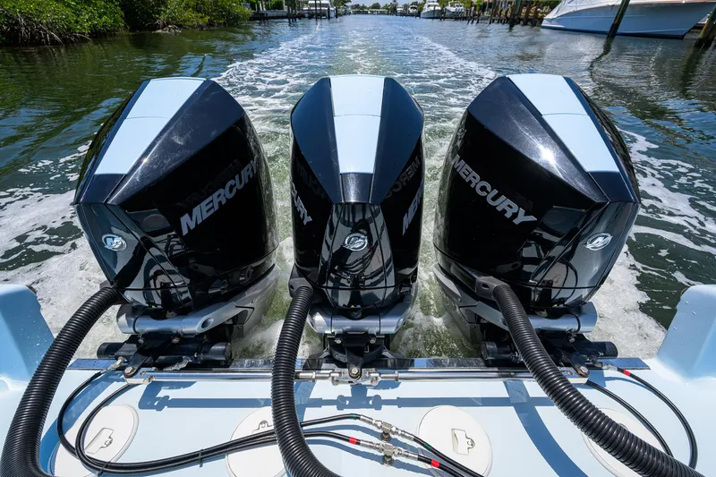  Yacht Photos Pics Triple Mercury outboard engines on a 2022 Fountain 34 CC boat, cruising through water.