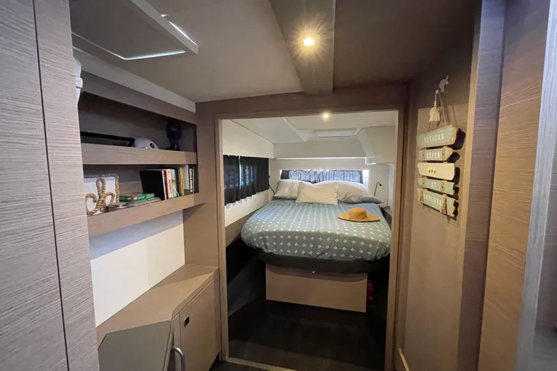 No Brainer Yacht Photos Pics Interior of 2022 Fountaine Pajot Catamaran Astrea 42 with cozy bedroom and wooden shelves.