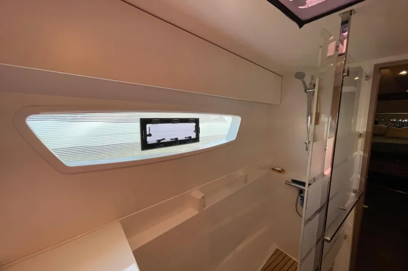 No Brainer Yacht Photos Pics Modern bathroom interior of 2022 Fountaine Pajot Catamaran Astrea 42 with shower and window.