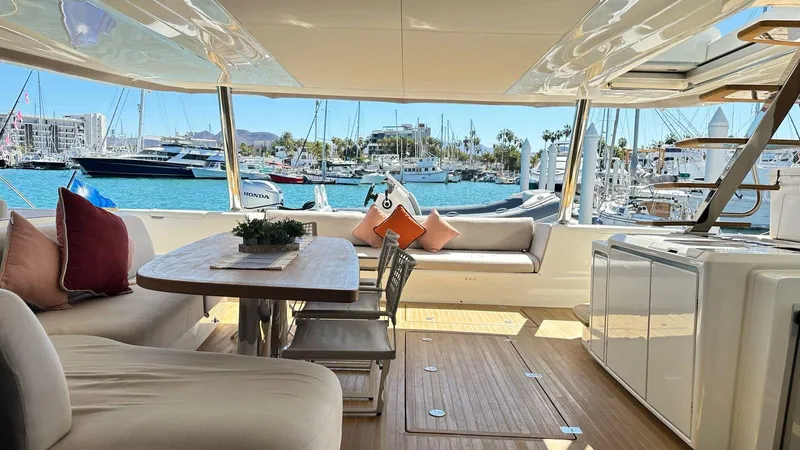  Yacht Photos Pics Luxurious Lagoon 65 yacht interior, 2022 model, featuring elegant seating and marina view.