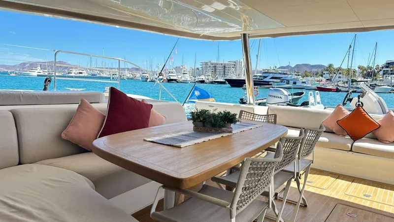  Yacht Photos Pics Luxurious Lagoon 65 yacht interior with elegant seating, dining table, and marina view.