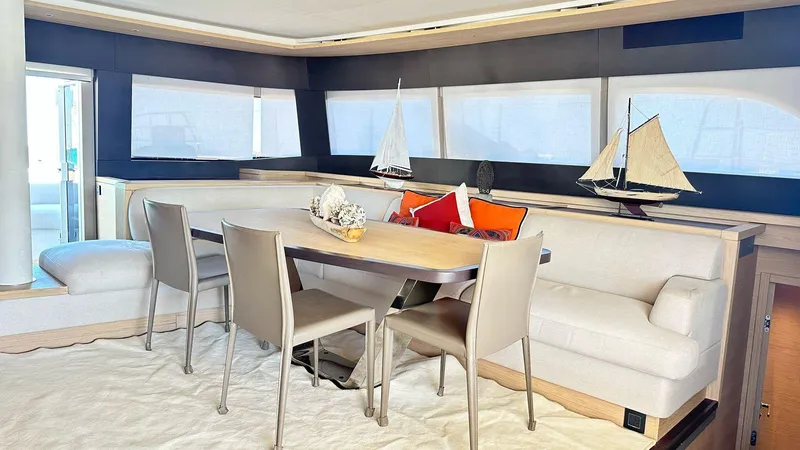  Yacht Photos Pics Luxurious interior of 2022 Lagoon 65 yacht with elegant dining area and model sailboats.