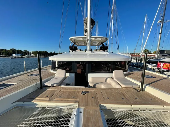  Yacht Photos Pics 2022 Lagoon 65 yacht with spacious deck and seating, docked at marina.