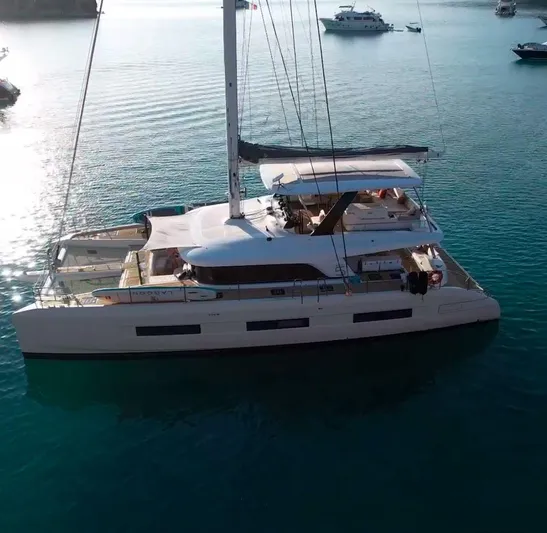  Yacht Photos Pics 2022 Lagoon 65 catamaran sailing on calm blue waters.