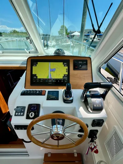 Mr. Sandman Yacht Photos Pics 2023 Back Cove 34O helm with navigation display and controls, docked at marina.