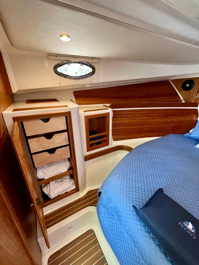 Mr. Sandman Yacht Photos Pics 2023 Back Cove 34O cabin interior with wooden storage and blue bedding.