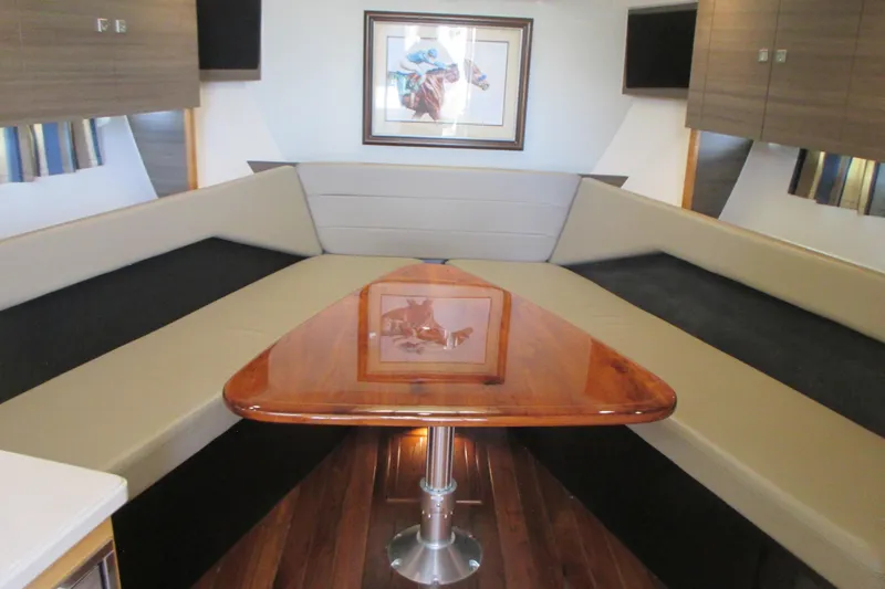 Worth Pursuit Yacht Photos Pics Interior of 2013 Pursuit SC 365i Sport Coupe with elegant seating and wooden table.