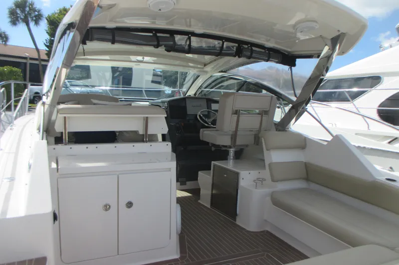 Worth Pursuit Yacht Photos Pics 2013 Pursuit SC 365i Sport Coupe interior with seating and helm, docked under sunny skies.