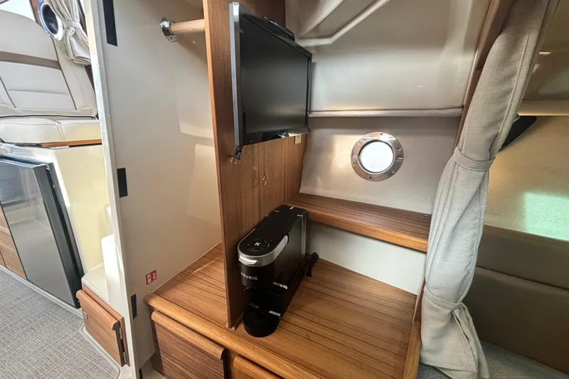  Yacht Photos Pics 2026 Ranger Tugs R-27 interior with TV, coffee maker, and porthole window.