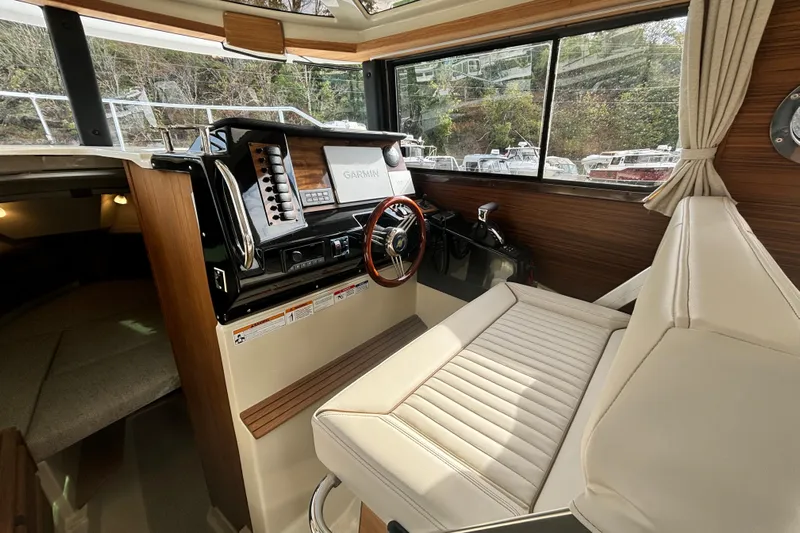  Yacht Photos Pics 2026 Ranger Tugs R-27 helm with Garmin navigation, luxurious seating, and wood accents.