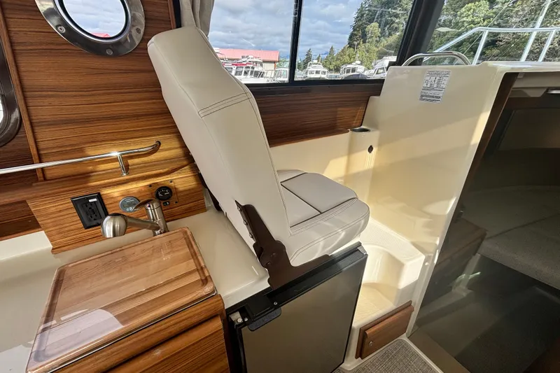 Yacht Photos Pics Interior of 2026 Ranger Tugs R-27 boat with helm seat and wooden accents.