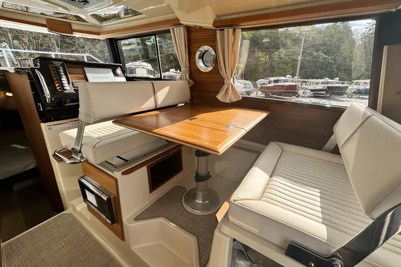  Yacht Photos Pics 2026 Ranger Tugs R-27 interior with dining area, wood table, and cushioned seating.