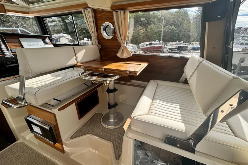  Yacht Photos Pics 2026 Ranger Tugs R-27 interior with seating, table, and window view.