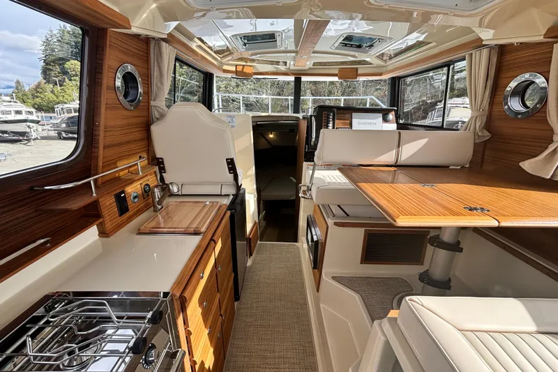  Yacht Photos Pics Interior of 2026 Ranger Tugs R-27 boat, featuring modern kitchen and seating area.