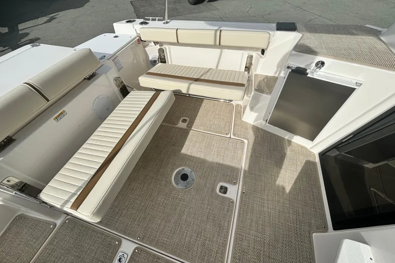  Yacht Photos Pics 2026 Ranger Tugs R-27 boat interior with beige seating and carpeted flooring.