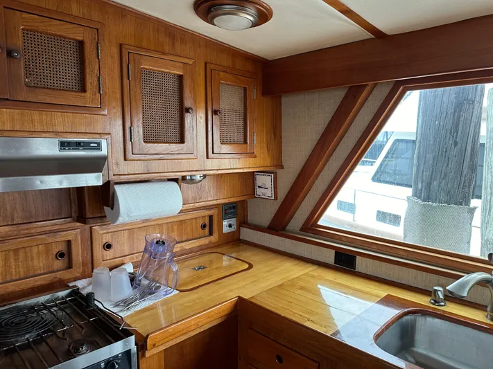 Gitana Yacht Photos Pics 1986 Wilbur Hunt Yachts kitchen interior with wooden cabinetry and modern appliances.