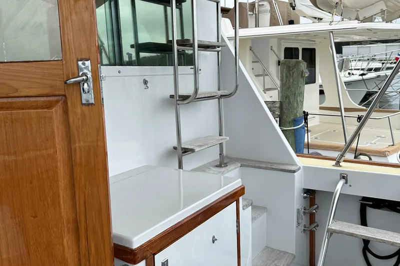 Gitana Yacht Photos Pics 1986 Wilbur Hunt Yachts boat with wooden door, metal ladder, and docked in a marina.