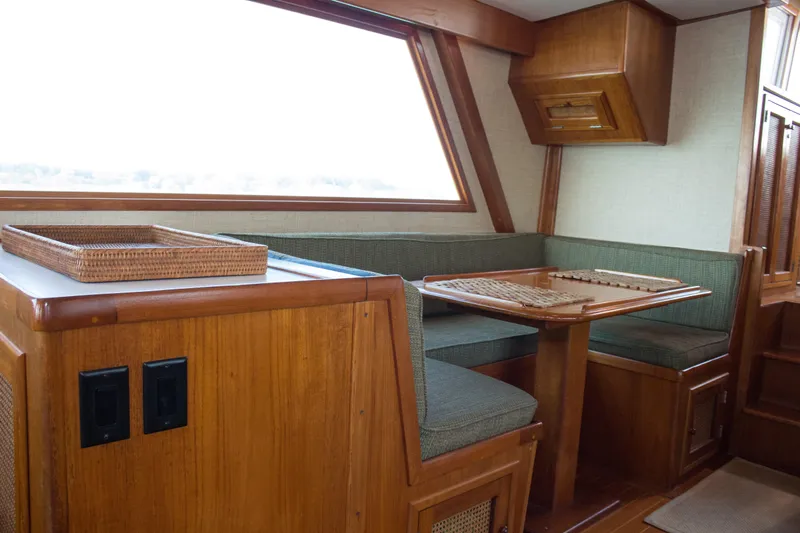 Gitana Yacht Photos Pics 1986 Wilbur Hunt Yachts interior with wooden dining area and green cushioned seating.