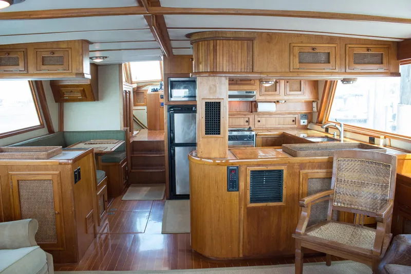 Gitana Yacht Photos Pics 1986 Wilbur Hunt Yachts interior with wooden cabinetry, kitchen, and seating area.