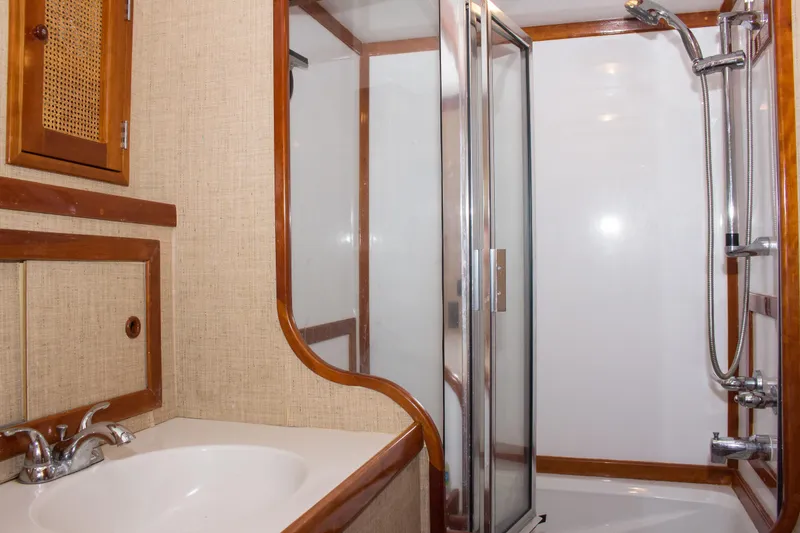 Gitana Yacht Photos Pics 1986 Wilbur Hunt Yachts bathroom with sink, shower, and wooden accents.
