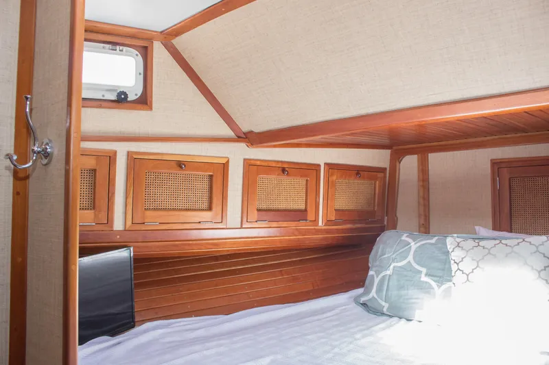 Gitana Yacht Photos Pics Cozy cabin interior of 1986 Wilbur Hunt Yachts with wooden accents and bedding.