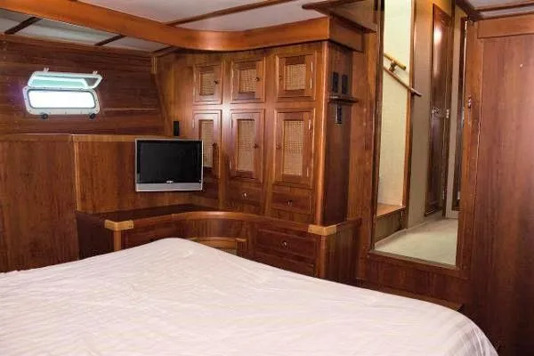 Gitana Yacht Photos Pics Luxurious 1986 Wilbur Hunt Yachts cabin interior with wood paneling and cozy bed.
