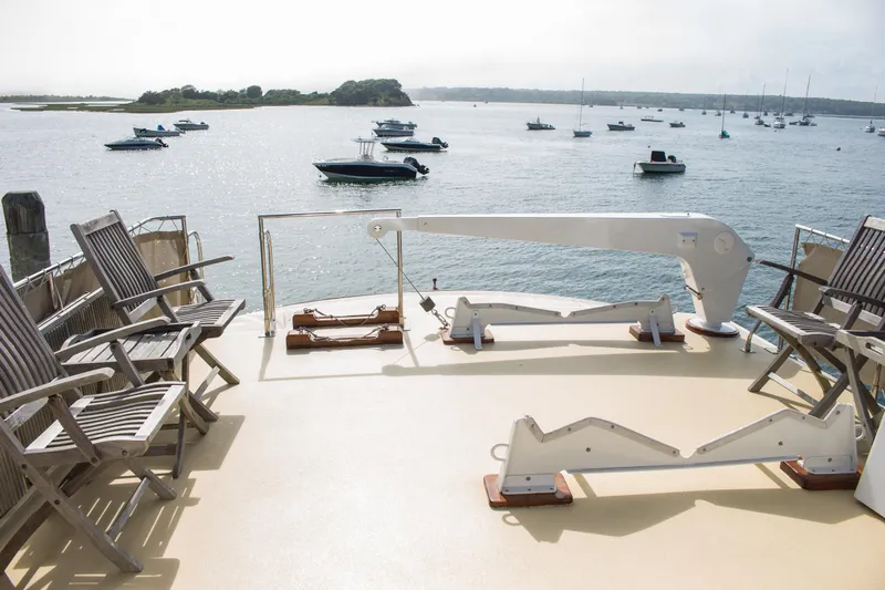 Gitana Yacht Photos Pics Deck of 1986 Wilbur Hunt Yacht with chairs overlooking serene harbor and anchored boats.