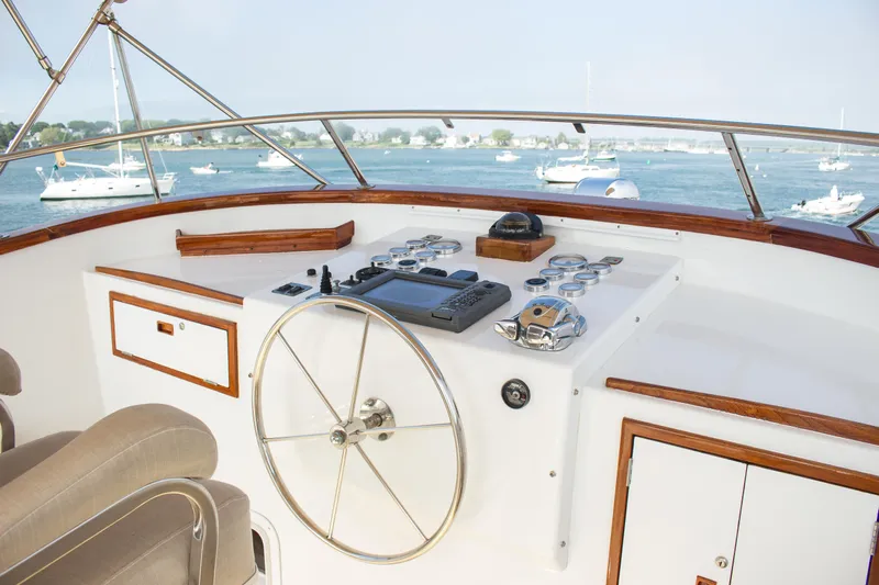 Gitana Yacht Photos Pics Helm of 1986 Wilbur Hunt Yachts boat with steering wheel and control panel, overlooking water.