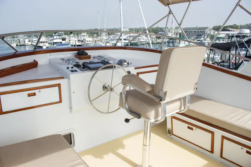 Gitana Yacht Photos Pics Captain's chair and helm on 1986 Wilbur Hunt Yachts, overlooking marina with boats.