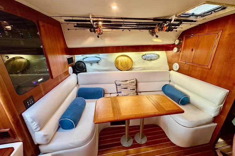  Yacht Photos Pics Cozy interior of 2000 Tiara 37 Open yacht with wooden table and white seating.