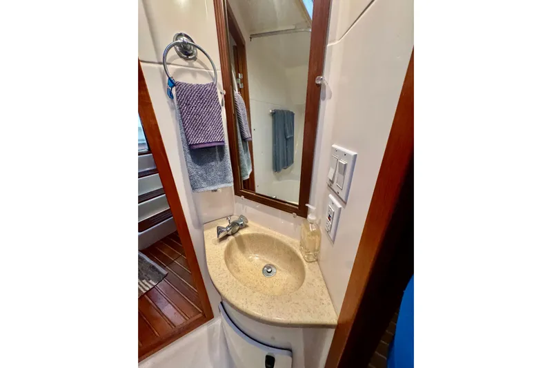  Yacht Photos Pics Bathroom sink area in a 2000 Tiara 37 Open yacht, featuring a mirror and towel rack.