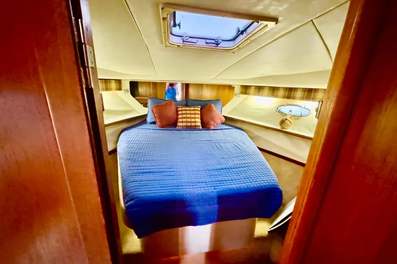  Yacht Photos Pics Cozy cabin interior of 2000 Tiara 37 Open yacht with blue bedding and porthole.