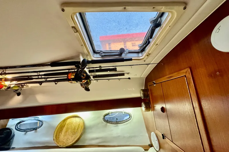  Yacht Photos Pics Interior of 2000 Tiara 37 Open boat with fishing rods and wooden cabinetry.