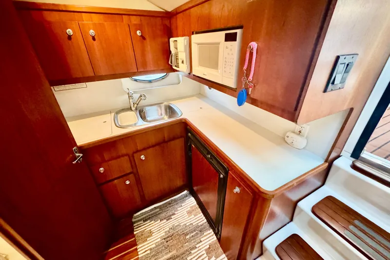  Yacht Photos Pics Compact kitchen in 2000 Tiara 37 Open yacht with wood cabinets and modern appliances.