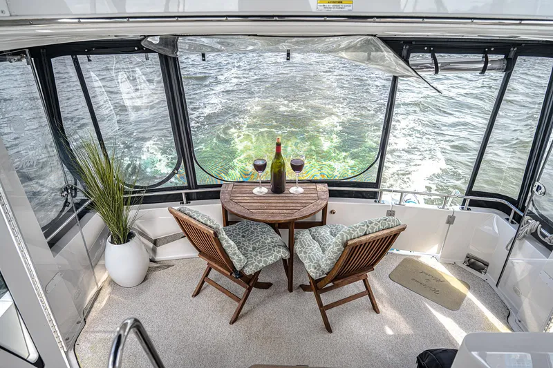 Fiesta Bayb Yacht Photos Pics 2003 Carver 444 Cockpit Motor Yacht interior with table, chairs, wine, and ocean view.