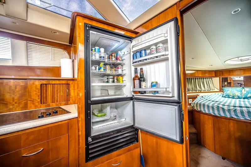 Fiesta Bayb Yacht Photos Pics Interior of 2003 Carver 444 Cockpit Motor Yacht with open fridge and cozy bedroom.